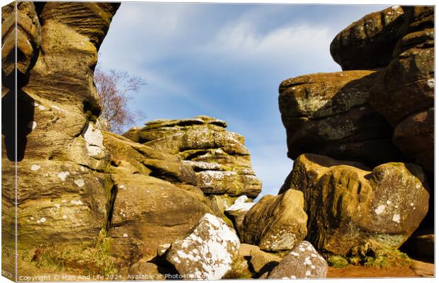 Scenic view of weathered rock formations under a blue sky with clouds at Brimham Rocks, in North Yorkshire Canvas Print by Man And Life