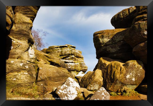 Scenic view of weathered rock formations under a blue sky with clouds at Brimham Rocks, in North Yorkshire Framed Print by Man And Life