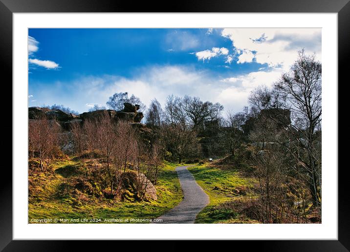 Scenic pathway through a lush park with rocky outcrops and vibrant blue sky with fluffy clouds at Brimham Rocks, in North Yorkshire Framed Mounted Print by Man And Life