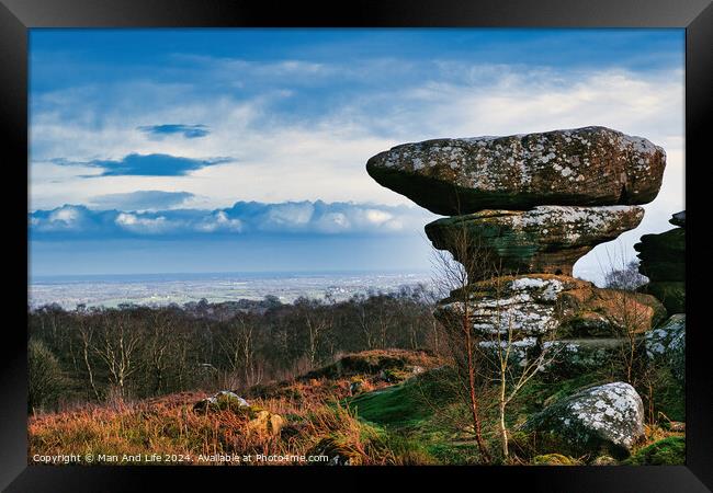 Scenic view of a unique rock formation in a lush landscape with dramatic clouds in the sky at Brimham Rocks, in North Yorkshire Framed Print by Man And Life