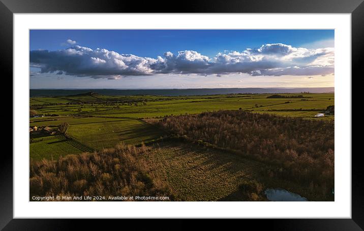 Aerial view of a lush countryside with fields and trees under a dramatic cloudy sky in North Yorkshire. Framed Mounted Print by Man And Life