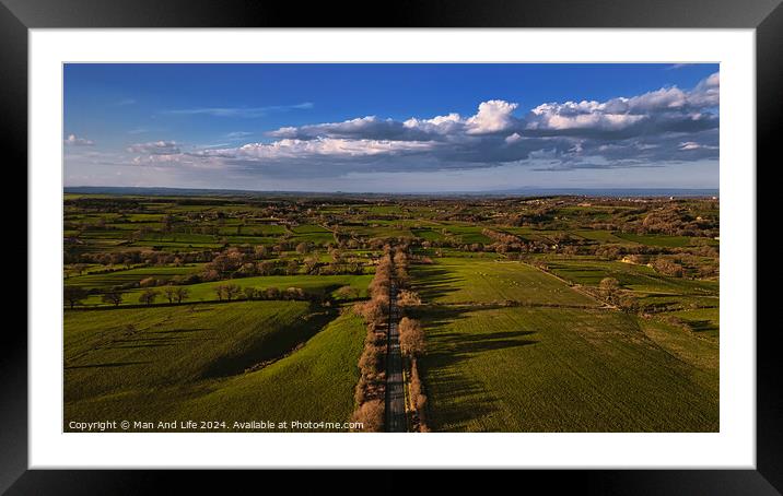 Aerial view of a lush green countryside with a road cutting through, under a vast blue sky with scattered clouds in North Yorkshire. Framed Mounted Print by Man And Life