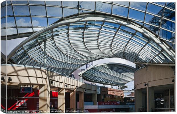Modern glass ceiling architecture at a shopping mall with blue sky and clouds visible through the transparent structure in Leeds, UK. Canvas Print by Man And Life