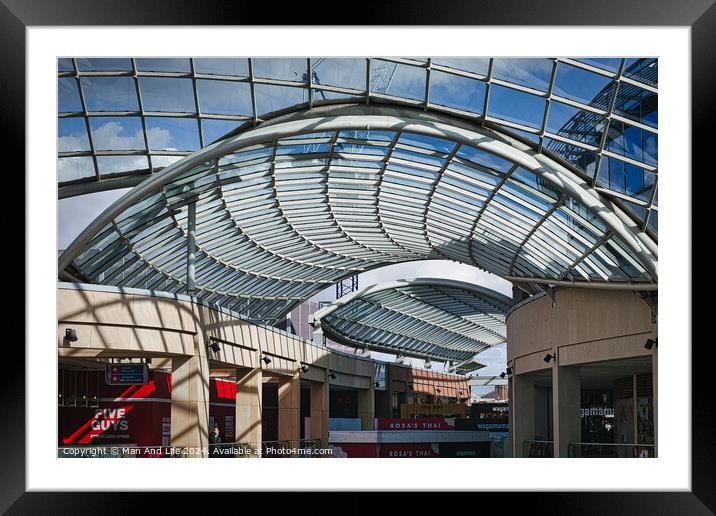Modern glass ceiling architecture at a shopping mall with blue sky and clouds visible through the transparent structure in Leeds, UK. Framed Mounted Print by Man And Life