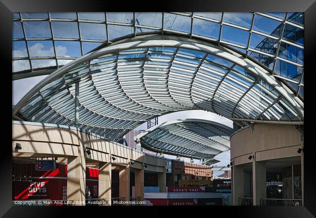 Modern glass ceiling architecture at a shopping mall with blue sky and clouds visible through the transparent structure in Leeds, UK. Framed Print by Man And Life