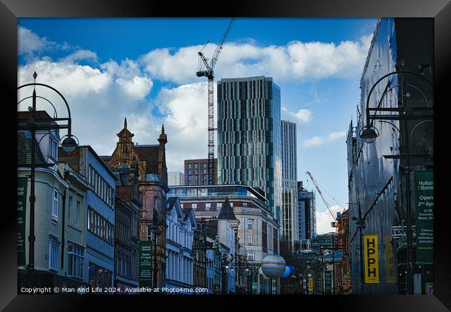 Urban cityscape with historic buildings and modern skyscraper under construction against a blue sky with clouds in Leeds, UK. Framed Print by Man And Life