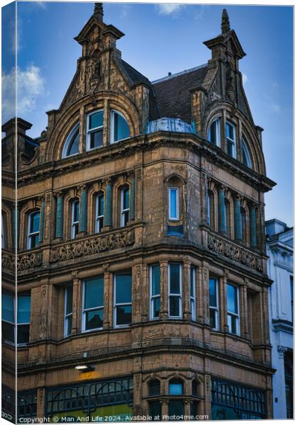 Victorian architecture with ornate details on a historic building's facade against a blue sky in Leeds, UK. Canvas Print by Man And Life