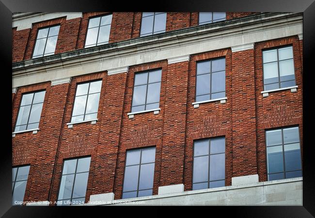 Facade of a brick building with symmetrical windows reflecting the sky, architectural background in Leeds, UK. Framed Print by Man And Life