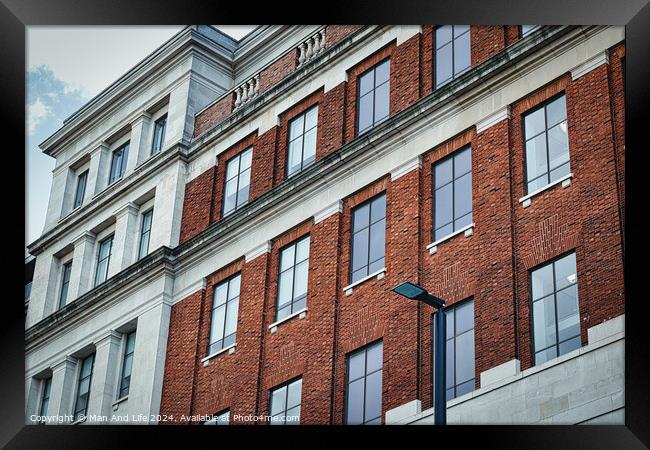 Classic brick building facade with large windows and decorative cornices, under a clear sky in Leeds, UK. Framed Print by Man And Life