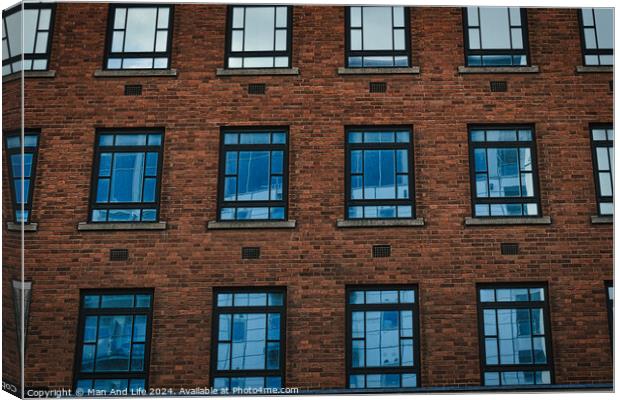 Symmetrical brick building facade with rows of blue windows, urban architecture background in Leeds, UK. Canvas Print by Man And Life