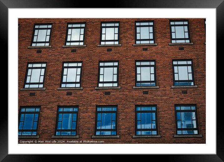 Facade of a brick building with symmetrical windows reflecting the sky in Leeds, UK. Framed Mounted Print by Man And Life