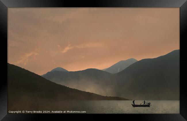 Sunset over the mountains with a silhouetted fishing boat Framed Print by Terry Brooks
