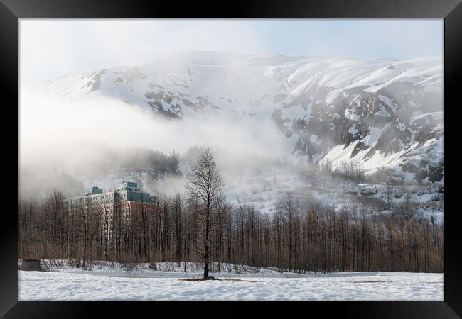 Mist and Fog swirls around Begich Towers Condominium building and the mountains behind, Whittier, Alaska, USA Framed Print by Dave Collins