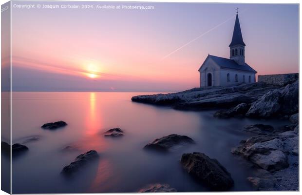 A church stands tall on a rocky shore next to the ocean, with the sunset on the horizon. Canvas Print by Joaquin Corbalan