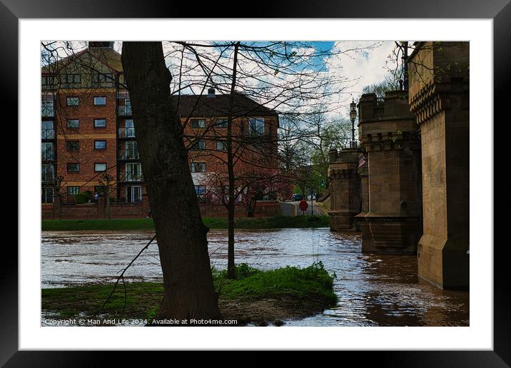 Urban riverside scene with swollen river waters, lush greenery, and a backdrop of modern residential buildings, showcasing the contrast between nature and urban development in York, North Yorkshire, England. Framed Mounted Print by Man And Life