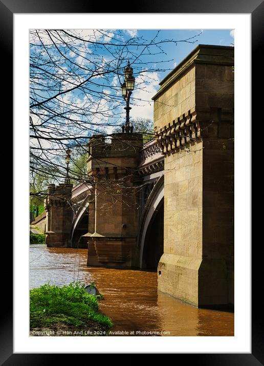 Scenic view of an old stone bridge with arches over a river, framed by blue skies and greenery, with a vintage street lamp adding to the historic charm in York, North Yorkshire, England. Framed Mounted Print by Man And Life