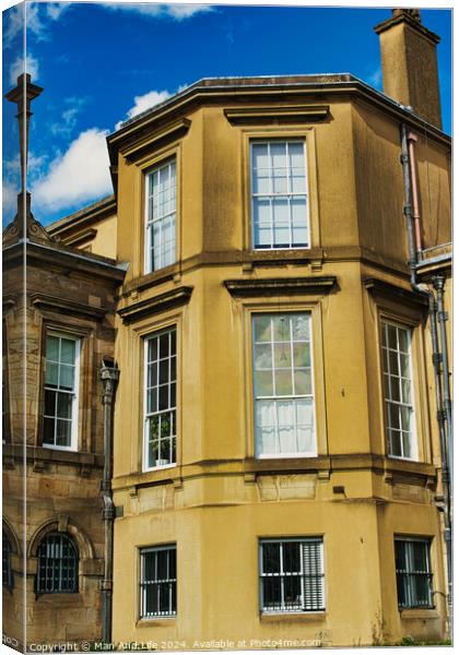 Classic European architecture with a clear blue sky. The building features a warm beige facade, large windows, and traditional stonework details in York, North Yorkshire, England. Canvas Print by Man And Life