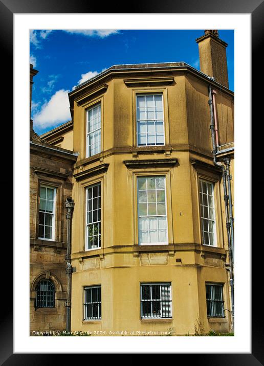 Classic European architecture with a clear blue sky. The building features a warm beige facade, large windows, and traditional stonework details in York, North Yorkshire, England. Framed Mounted Print by Man And Life