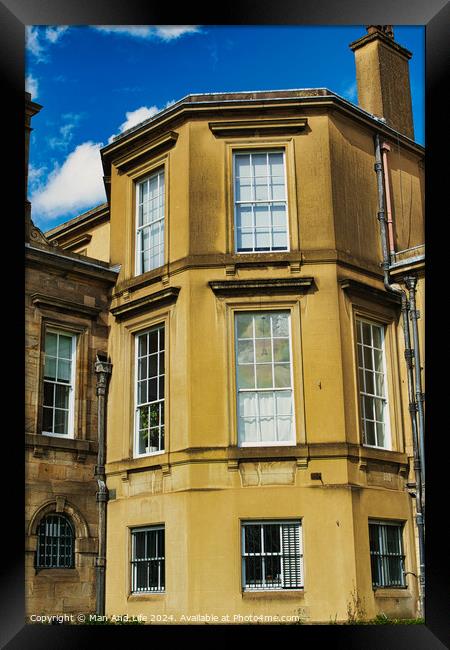 Classic European architecture with a clear blue sky. The building features a warm beige facade, large windows, and traditional stonework details in York, North Yorkshire, England. Framed Print by Man And Life