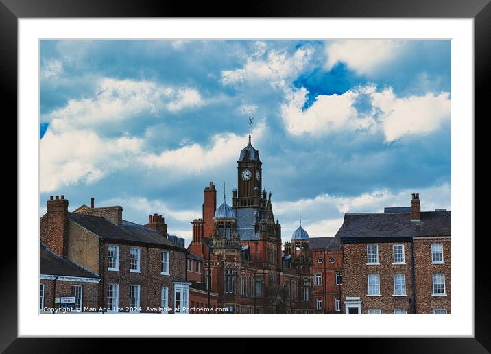 Dramatic clouds loom over a historic town center, featuring a prominent clock tower and classic brick buildings, capturing a quintessential British townscape in York, North Yorkshire, England. Framed Mounted Print by Man And Life