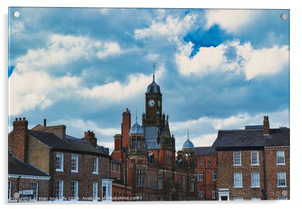 Dramatic clouds loom over a historic town center, featuring a prominent clock tower and classic brick buildings, capturing a quintessential British townscape in York, North Yorkshire, England. Acrylic by Man And Life