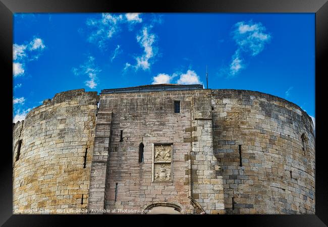 Medieval stone fortress against a vibrant blue sky with fluffy clouds, showcasing ancient architecture and historical military construction in York, North Yorkshire, England. Framed Print by Man And Life