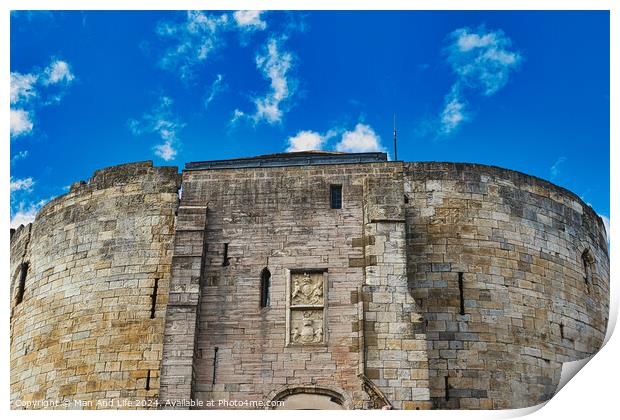 Medieval stone fortress against a vibrant blue sky with fluffy clouds, showcasing ancient architecture and historical military construction in York, North Yorkshire, England. Print by Man And Life