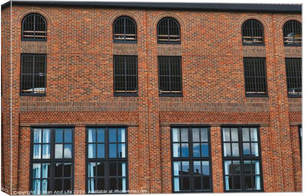 Facade of a vintage brick building with rows of windows reflecting the sky, showcasing industrial architecture in York, North Yorkshire, England. Canvas Print by Man And Life