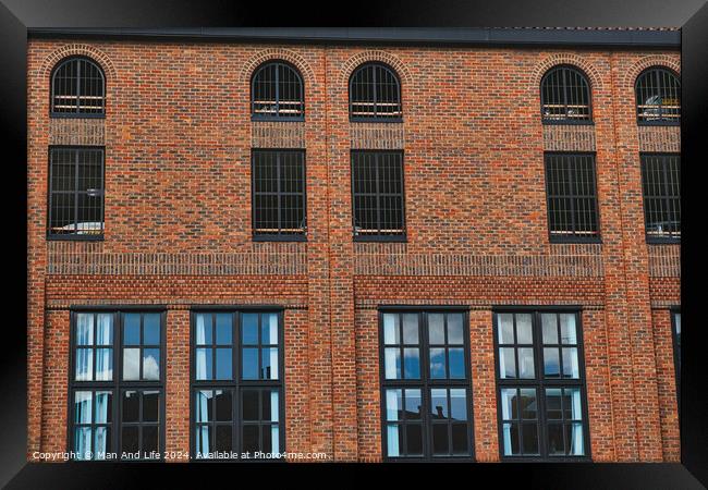 Facade of a vintage brick building with rows of windows reflecting the sky, showcasing industrial architecture in York, North Yorkshire, England. Framed Print by Man And Life