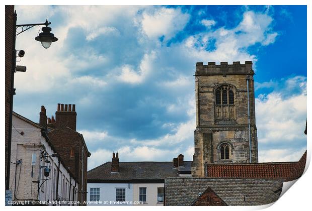 Quaint European street with historic buildings and a prominent church tower under a dramatic sky with fluffy clouds in York, North Yorkshire, England. Print by Man And Life