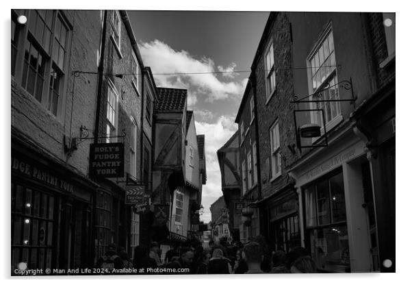 Black and white image of a bustling narrow street in York, with historic buildings, quaint shops, and pedestrians exploring the charming old town in York, North Yorkshire, England. Acrylic by Man And Life