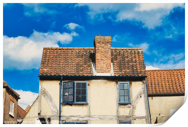 Old European building with weathered facade and terracotta roof tiles against a backdrop of a vibrant blue sky with fluffy clouds in York, North Yorkshire, England. Print by Man And Life