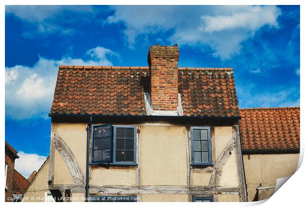 Old European house with half-timbered walls and a red tiled roof against a blue sky with clouds. Vintage architecture with visible wear and character in York, North Yorkshire, England. Print by Man And Life