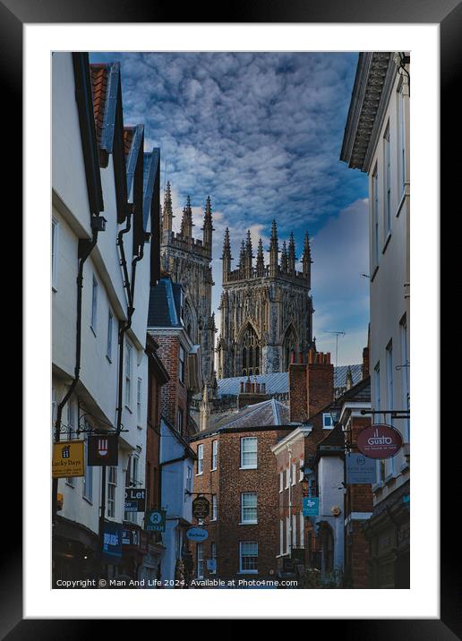 Historic European cityscape with Gothic cathedral towering over traditional buildings under a dramatic cloudy sky in York, North Yorkshire, England. Framed Mounted Print by Man And Life
