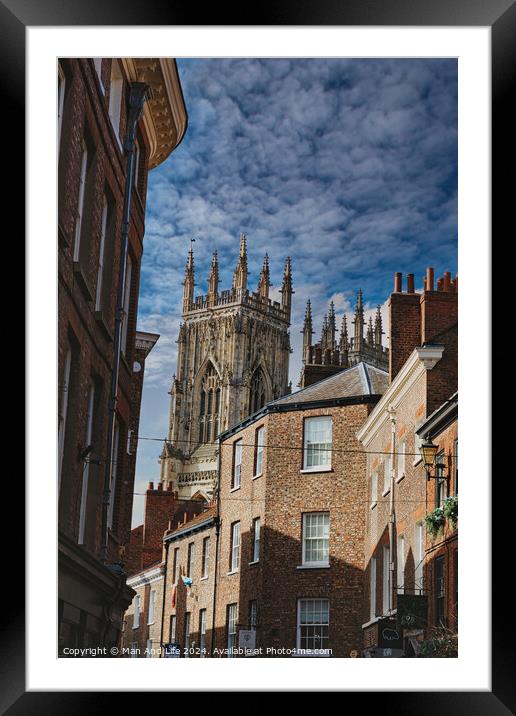 Quaint cobbled street leading to a majestic Gothic cathedral under a blue sky with wispy clouds, showcasing historical architecture and urban charm in York, North Yorkshire, England. Framed Mounted Print by Man And Life