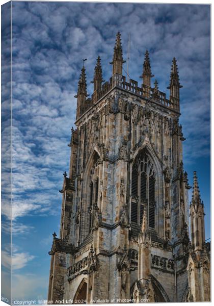 Gothic cathedral tower against a dramatic cloudy sky, showcasing intricate architectural details and spires, ideal for historical or religious themes in York, North Yorkshire, England. Canvas Print by Man And Life