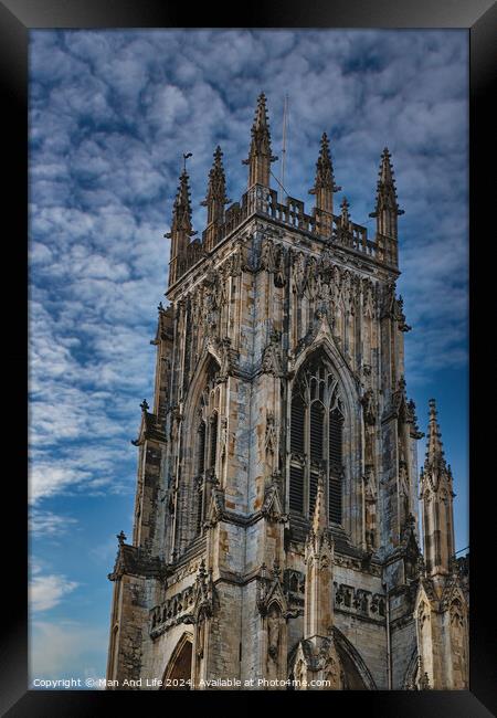 Gothic cathedral tower against a dramatic cloudy sky, showcasing intricate architectural details and spires, ideal for historical or religious themes in York, North Yorkshire, England. Framed Print by Man And Life