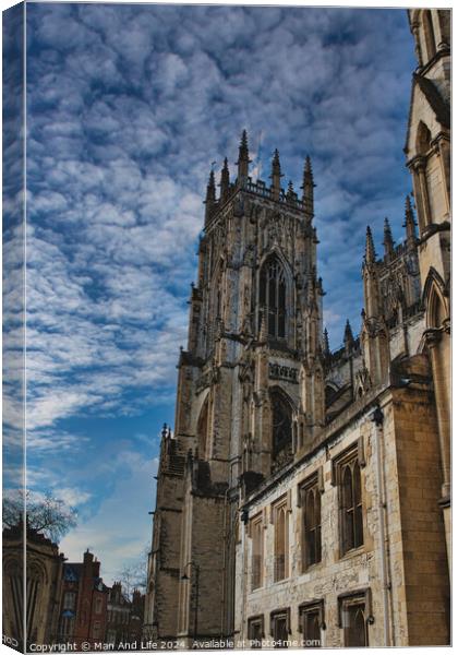 Gothic cathedral against a dramatic sky with fluffy clouds, showcasing intricate architecture and historical grandeur, ideal for travel and cultural themes in York, North Yorkshire, England. Canvas Print by Man And Life
