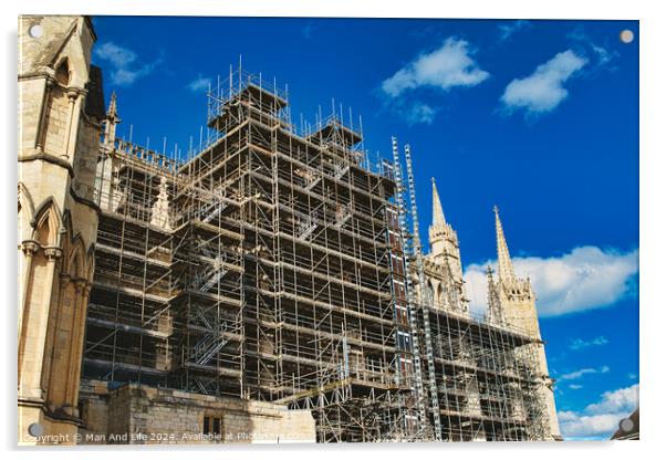 Historic cathedral undergoing renovation, with intricate scaffolding against a bright blue sky with clouds. Architectural preservation concept in York, North Yorkshire, England. Acrylic by Man And Life