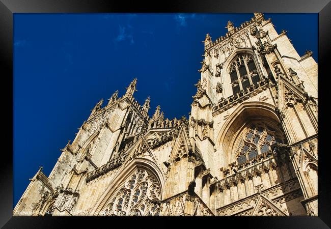 Gothic cathedral facade against a clear blue sky, showcasing intricate architectural details and stone carvings, perfect for historical and travel themes in York, North Yorkshire, England. Framed Print by Man And Life