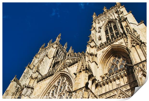Gothic cathedral facade against a clear blue sky, showcasing intricate architectural details and stone carvings, perfect for historical and travel themes in York, North Yorkshire, England. Print by Man And Life