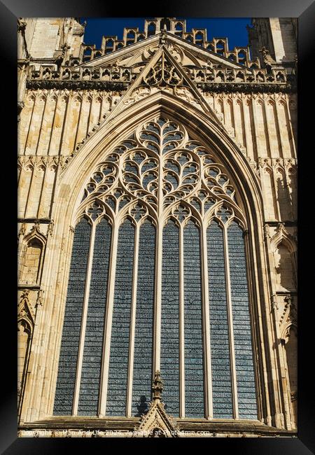 Gothic architecture detail of a cathedral window with intricate tracery and stained glass, set against a clear blue sky in York, North Yorkshire, England. Framed Print by Man And Life