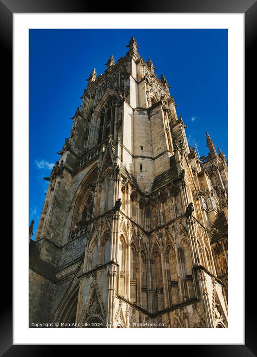 Gothic cathedral facade with intricate architecture against a clear blue sky, showcasing historical religious building's exterior details in York, North Yorkshire, England. Framed Mounted Print by Man And Life