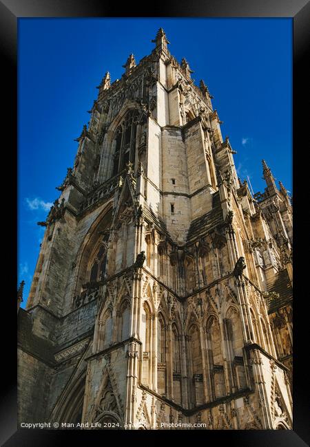 Gothic cathedral facade with intricate architecture against a clear blue sky, showcasing historical religious building's exterior details in York, North Yorkshire, England. Framed Print by Man And Life