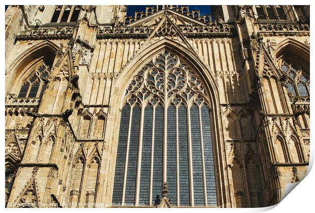 Gothic architecture detail of a cathedral's facade, featuring a large stained glass window and ornate stone carvings under clear skies in York, North Yorkshire, England. Print by Man And Life