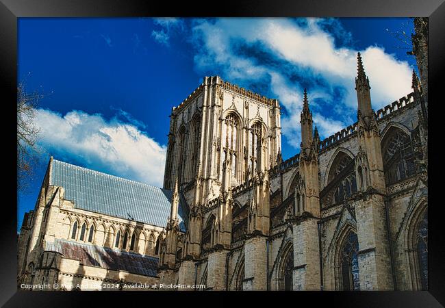 Majestic Gothic cathedral against a blue sky with fluffy clouds, showcasing intricate architecture and historical grandeur in York, North Yorkshire, England. Framed Print by Man And Life
