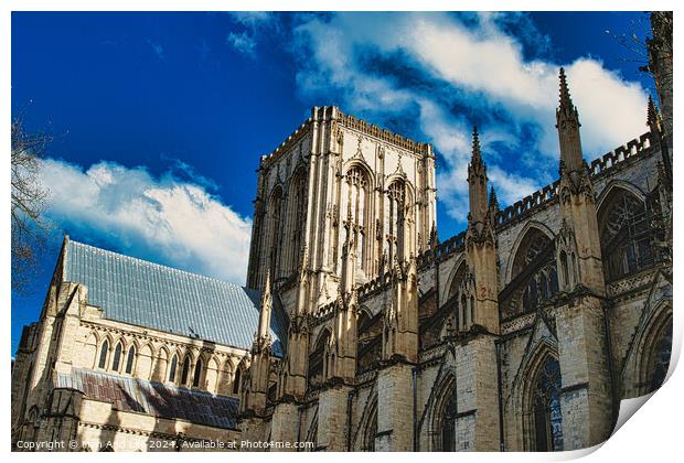 Majestic Gothic cathedral against a blue sky with fluffy clouds, showcasing intricate architecture and historical grandeur in York, North Yorkshire, England. Print by Man And Life