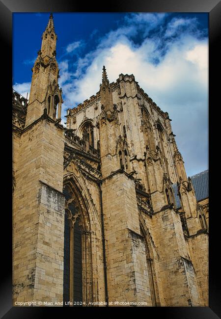 Gothic cathedral facade against a blue sky with clouds. The image captures the intricate architecture and towering spires of the historic religious building in York, North Yorkshire, England. Framed Print by Man And Life