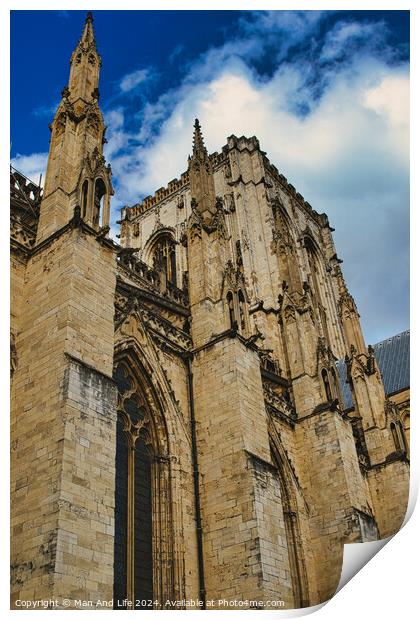 Gothic cathedral facade against a blue sky with clouds. The image captures the intricate architecture and towering spires of the historic religious building in York, North Yorkshire, England. Print by Man And Life