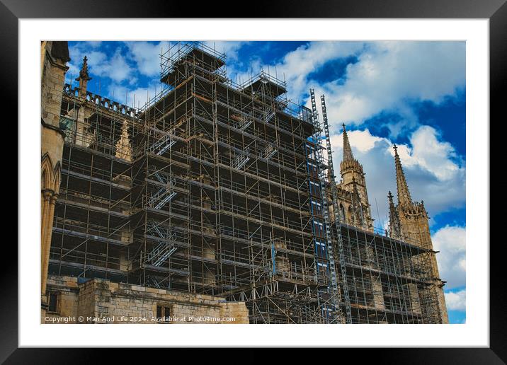 Gothic cathedral undergoing restoration, with extensive scaffolding against a dramatic cloudy sky in York, North Yorkshire, England. Framed Mounted Print by Man And Life